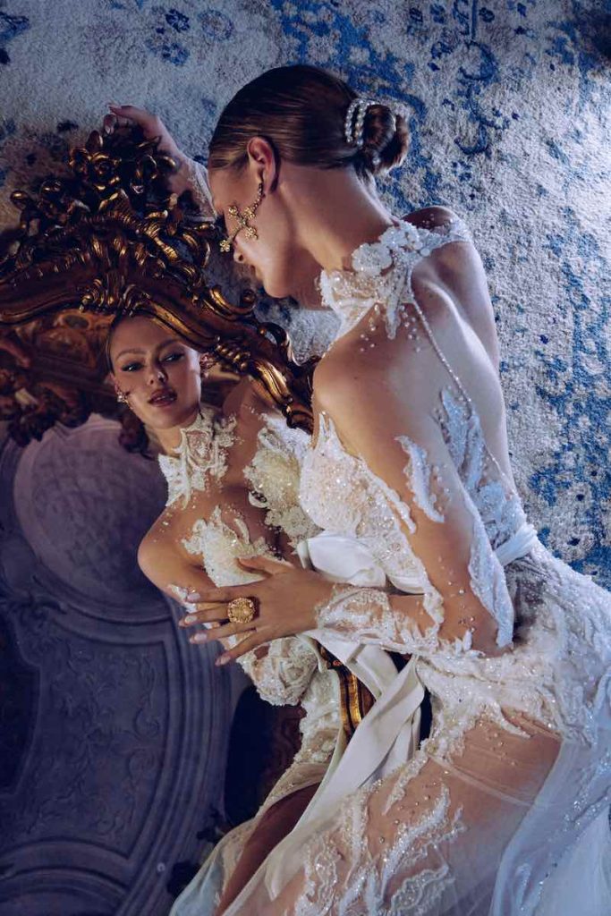 In questa foto una modella posa davanti ad uno specchio indossando un abito da sposa Maison Signore 2024