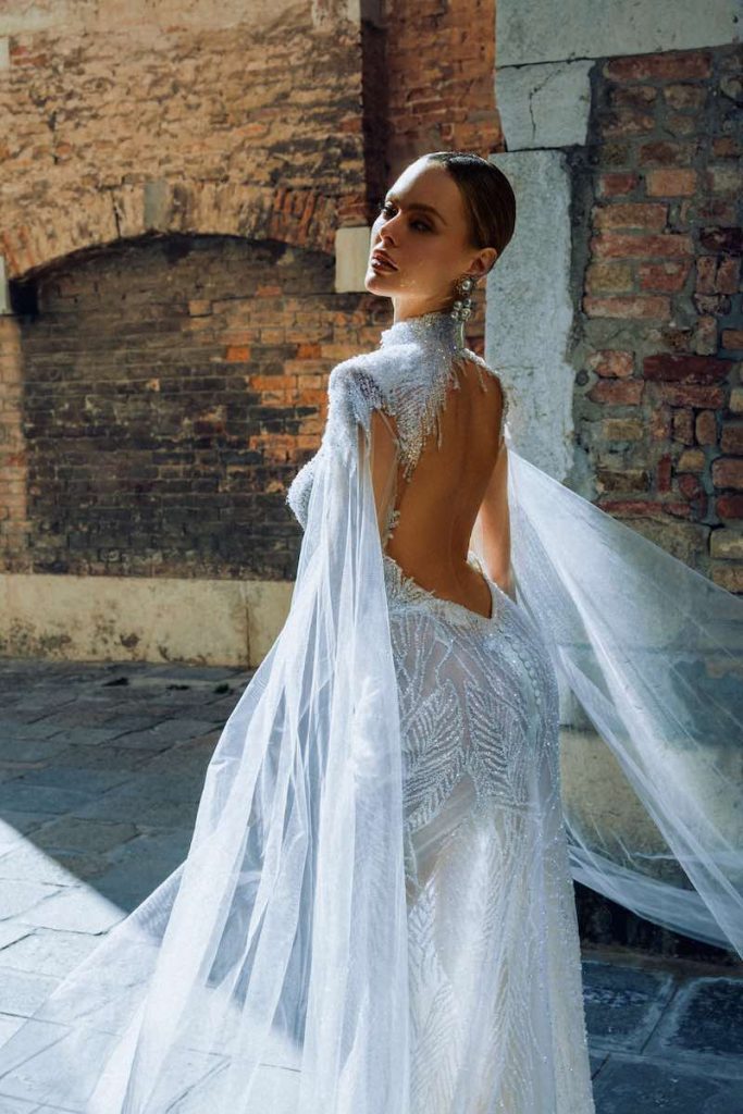 In questa foto una modella posa di spalle indossando un abito da sposa Maison Signore 2024