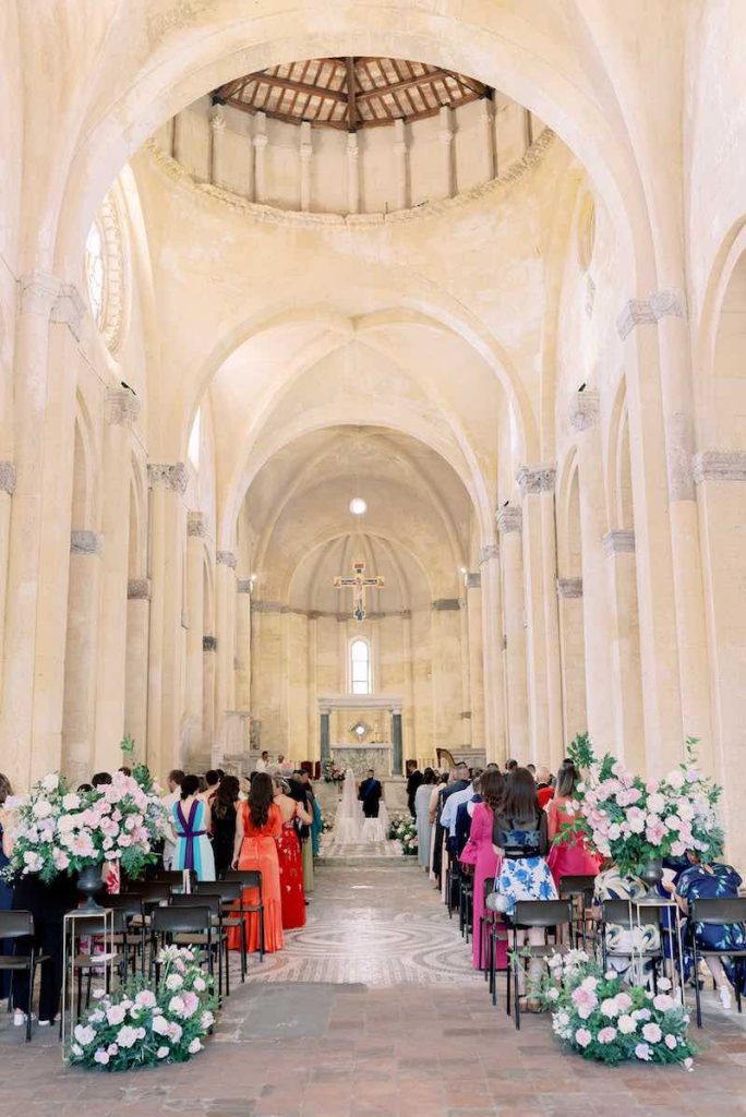 In questa foto la chiesa del matrimonio di Gabriele e Cecilia inquadrata dall'ingresso e decorata con composizioni di fiori di colore rosa 
