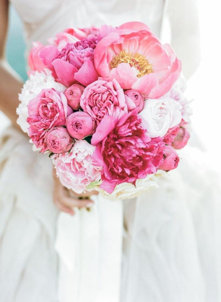 In questa foto un bouquet da sposa rotondo con fiori di colore rosa e rosa tenue