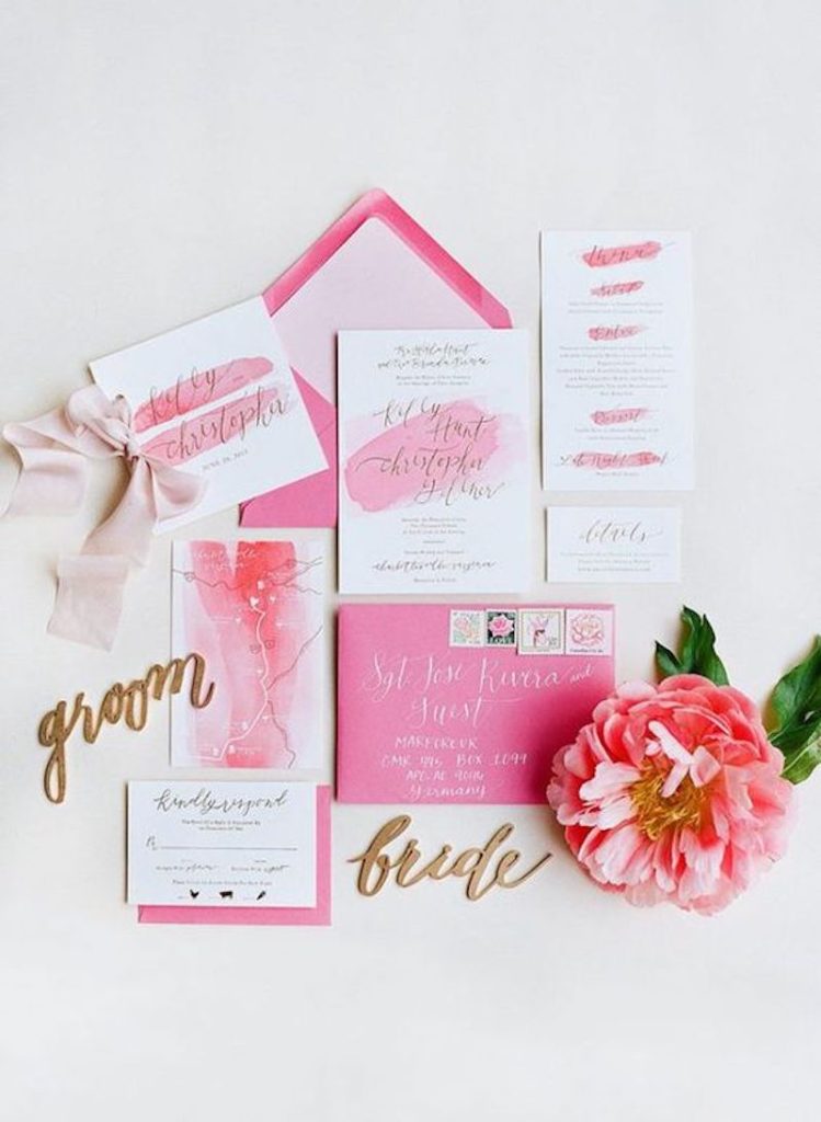 In questa foto una partecipazione matrimonio stile Barbie di colore rosa e bianca 