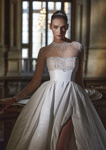 In questa foto un abito da sposa trasformabile di Pronovias Privée 2024 grazie alla scollatura illusion sul décolleté impreziosita da fili di perline