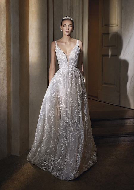 In questa foto un abito da sposa dalla linea ad A che si illumina grazie al ricamo realizzato in micro perline