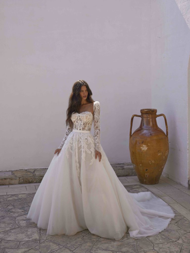 In questa immagine un vestito da sposa con corpetto in pizzo ed ampia gonna in tulle. 