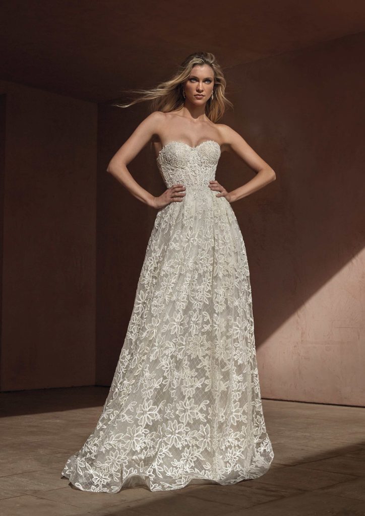 In questa immagine un abito interamente ricamato in pizzo della collezione sposa Pronovias 2024