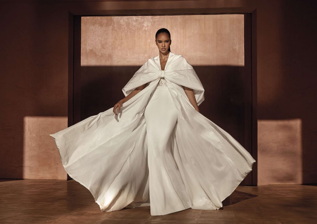 In questa immagine un abito da sposa con maxi cappotto. 