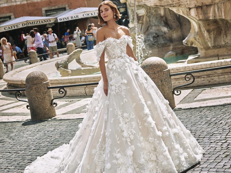 In questa foto una modella posa indossando uno degli abiti da sposa romantici 2024 Atelier Emé