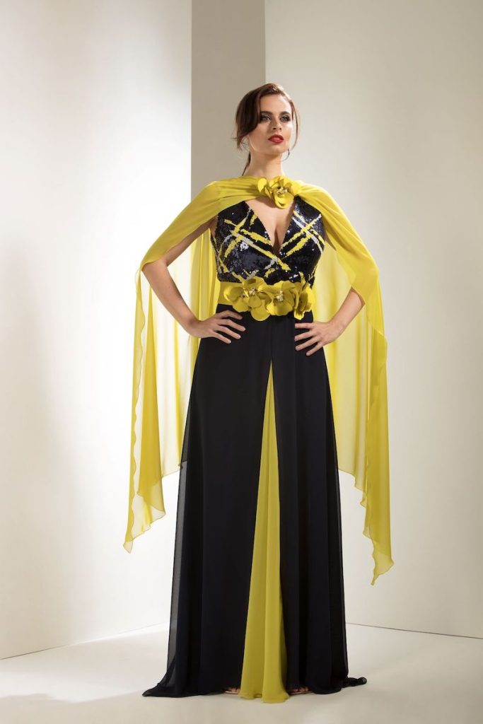 In questa foto una modella indossa un abito da cerimonia curvy lungo di colore nero e giallo lime con cappa abbinata in vendita presso Magazzini D'Amico a Palermo