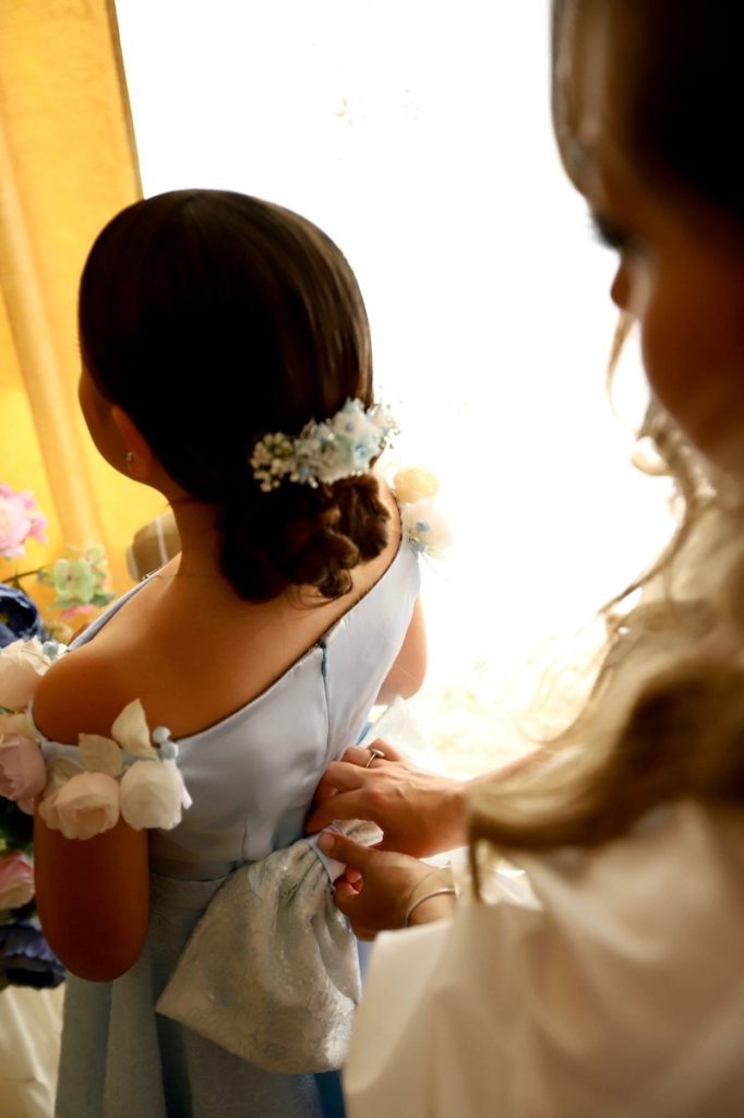 In questa foto la Wedding Planner Jenny Scalera chiude il vestito di una damigella 
