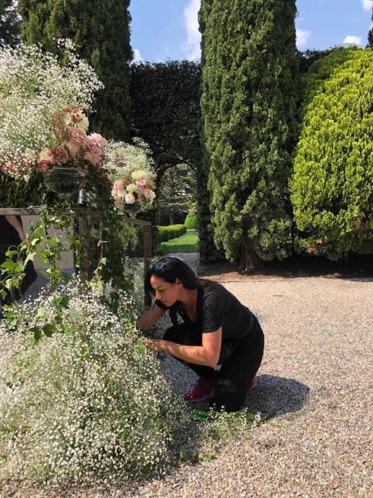 In questa foto la Wedding Planner Sonia Gatti, proprietaria di Tenuta Corte Vittoria, mentre sistema alcune decorazioni nel giardino della location