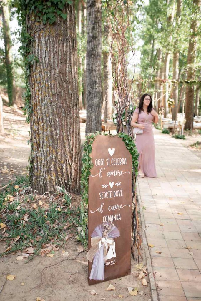 In questa foto il Welcome Table Mariage delle nozze di Alice e Michele realizzato in legno sul quale è scritto "Oggi si celebra l'amore, sedete dove il cuore comanda"