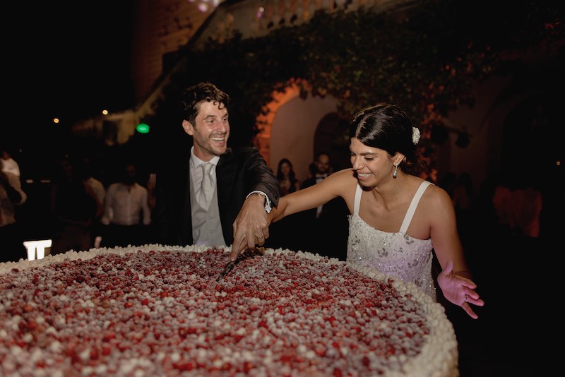 In questa foto gli sposi Elena e Nicola durante il taglio della loro maxi torta nuziale con panna e fragoline
