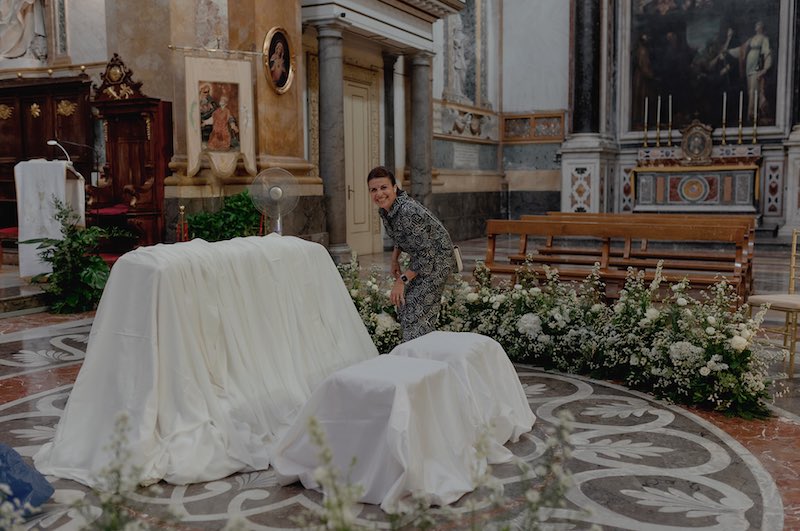 In questa foto la Wedding Planner Rita Mineo mentre sistema i fiori attorno all'altare della chiesa di Sant'Ignazio all'Olivella per il matrimonio di Elena e Nicola