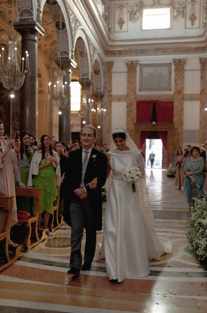 In questa foto Elena entra al braccio del papà camminando lungo la navata della chiesa di Sant'Ignazio all'Olivella 