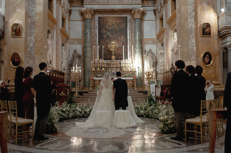 In questa foto gli sposi Elena e Nicola all'altare insieme ai testimoni inquadrati di spalle 