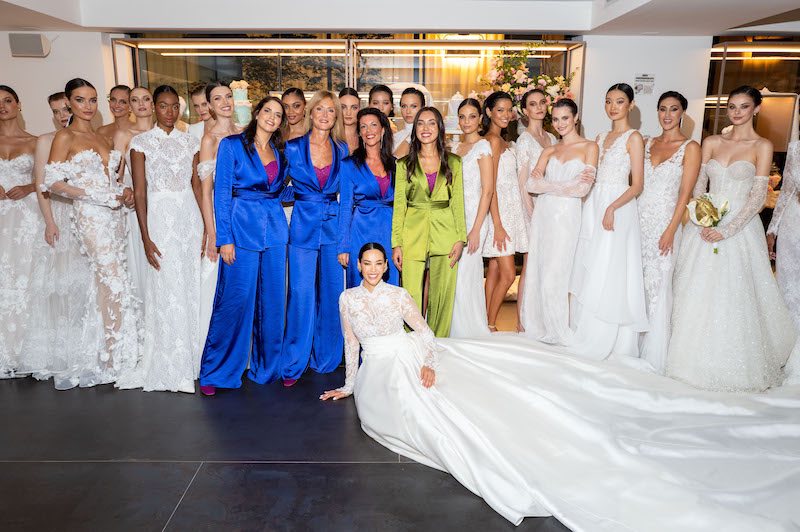 In questa foto la direttrice di Atelier Emé Silvia Falconi in tailleur colore verde pistacchio circondata dalle sue assistenti e dalle modelle che hanno sfilato sulla passerella di Opera Prima