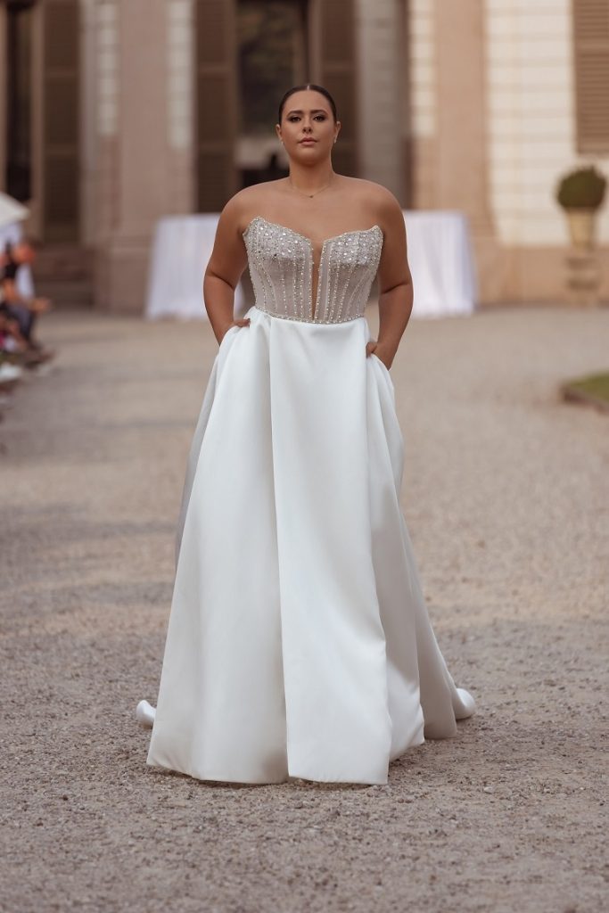 In questa immagine un abito da sposa 2024 con corpetto sparkling e gonna minimal.