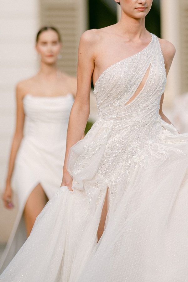 In questa immagine un abito da sposa con corpetto monospalla interamente ricoperto da dettagli preziosi. 