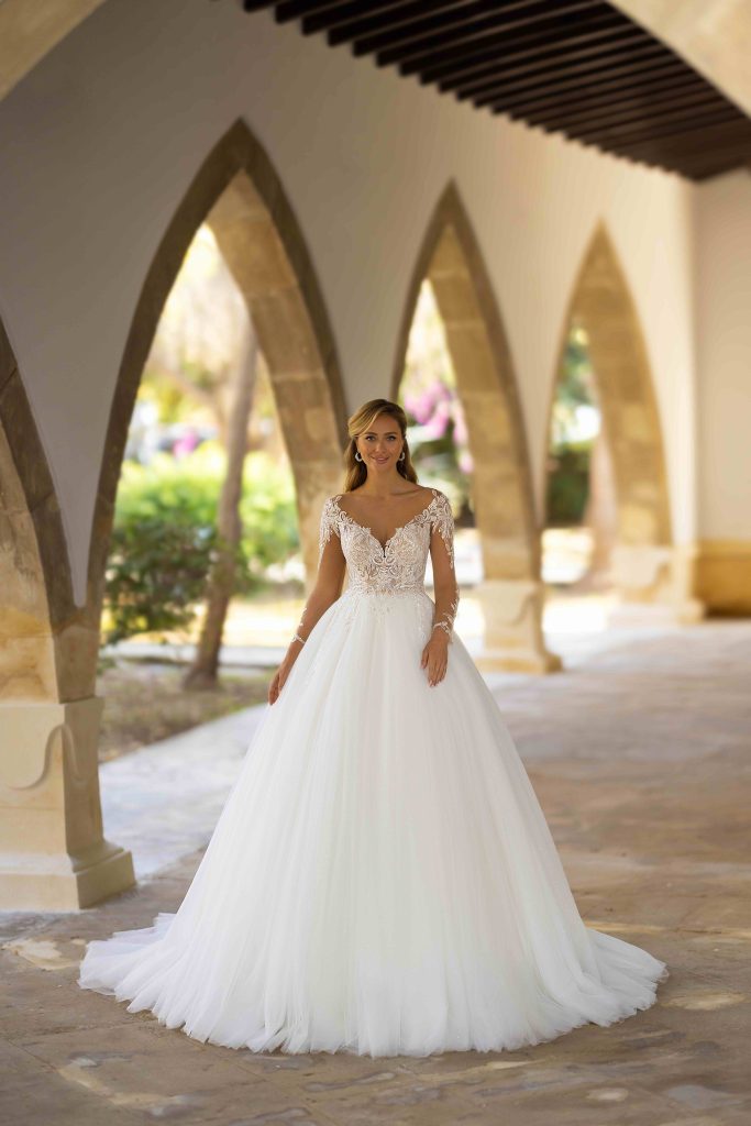 In questa immagine un abito da sposa da principessa 2024 con corpetto in pizzo e gonna in tulle di Monica Loretti