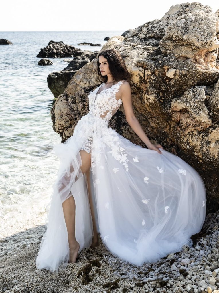 In questa immagine un abito da sposa con spacco profondo e corpetto in pizzo di Alessandro Angelozzi. 