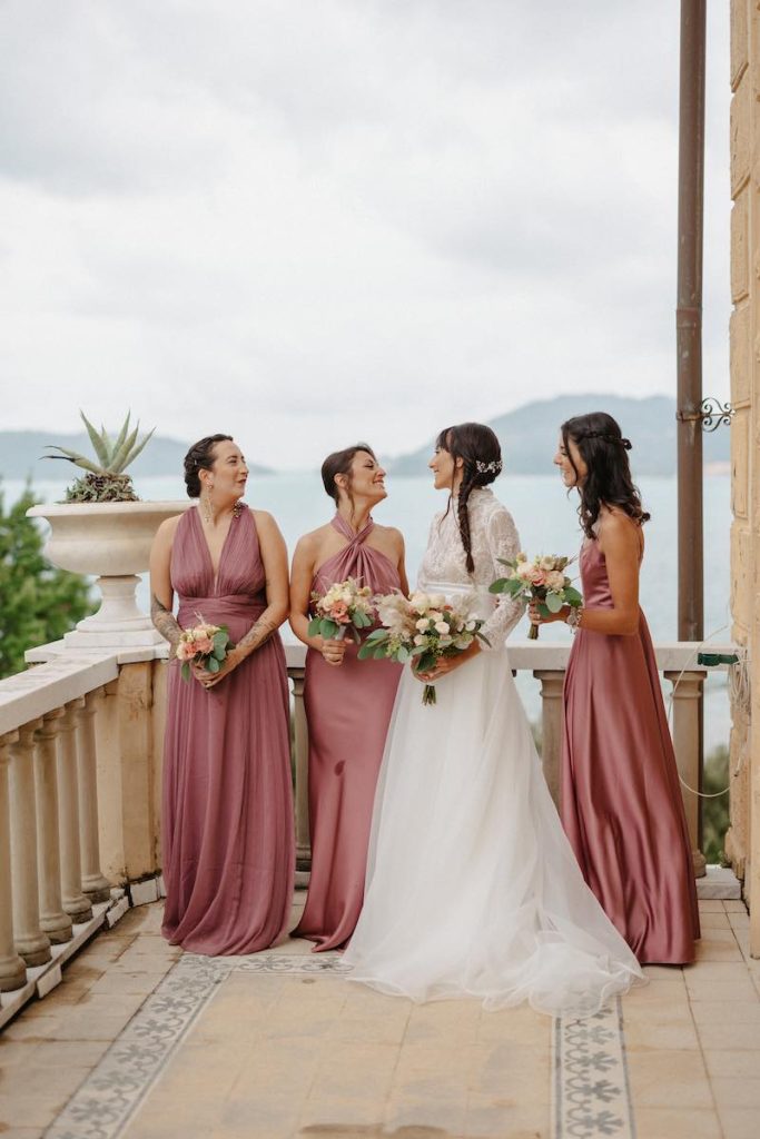 In questa foto la sposa Clara sul balcone di Villa Marigola a Lerici con le sue tre damigelle vestite con abiti di color malva