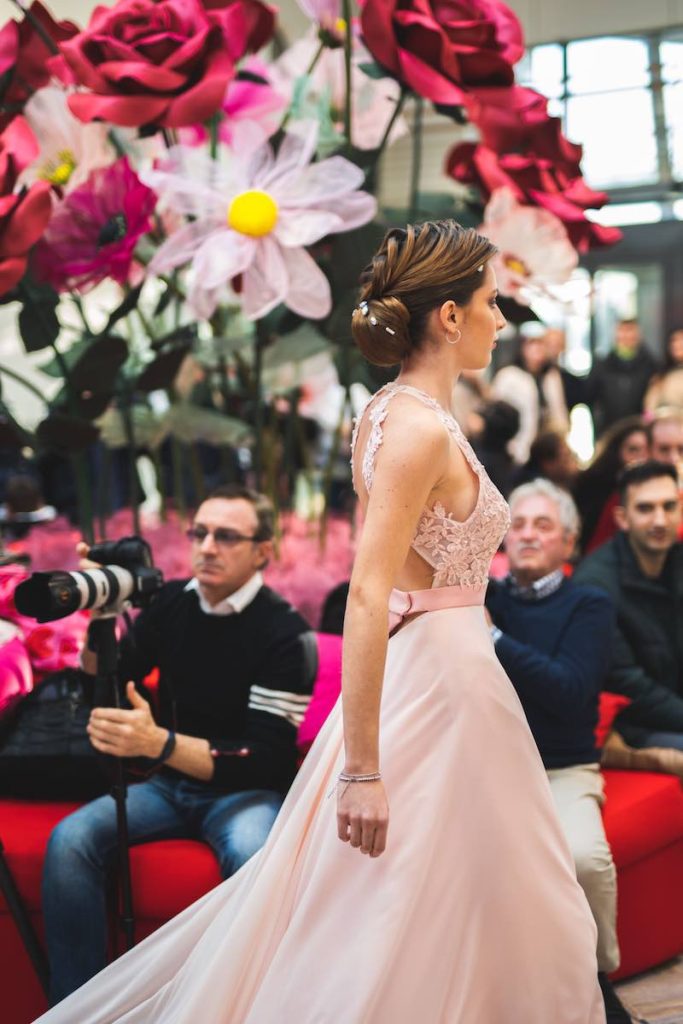 In questa foto una modella sfila a Bergamo Sposi con un abito da cerimonia di colore rosa cipria