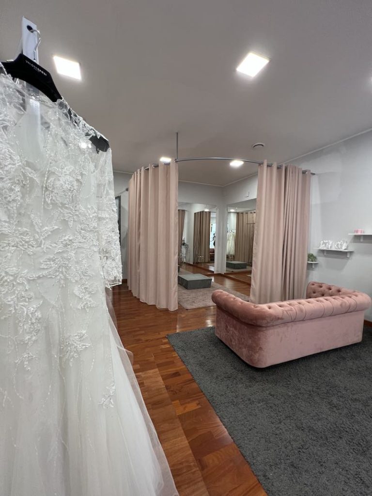 In questa foto uno degli atelier Valore Sposi con arredi di colore rosa cipria e in primo piano un abito da sposa in pizzo e tulle
