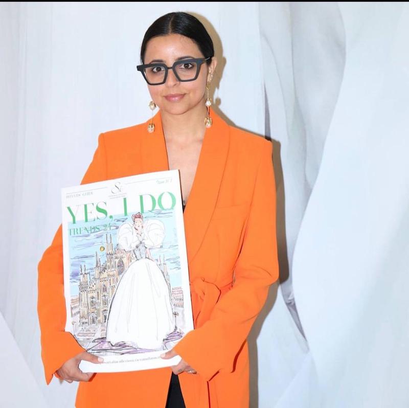 In questa foto la Bridal Stylist Giulia Solli tiene in mano il volantino del Sì Sposaitalia Collezioni 2023 per cui è stata scelta come ambassador