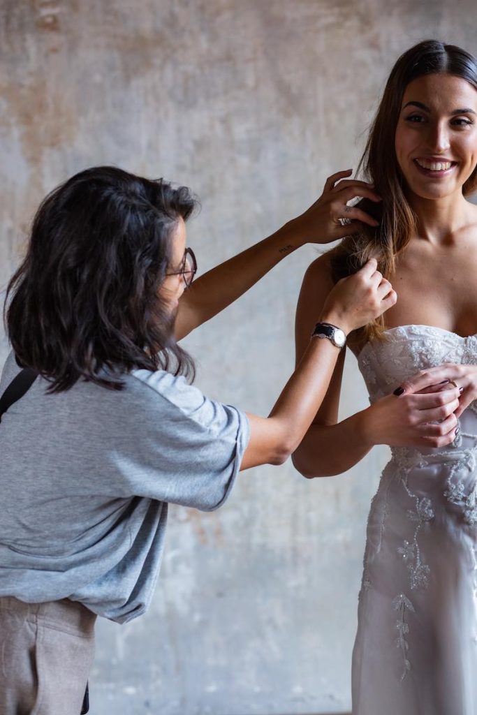 In questa foto la Bridal Stylist Giulia Solli di spalle sistema l'acconciatura di una sposa durante lo shooting di nozze