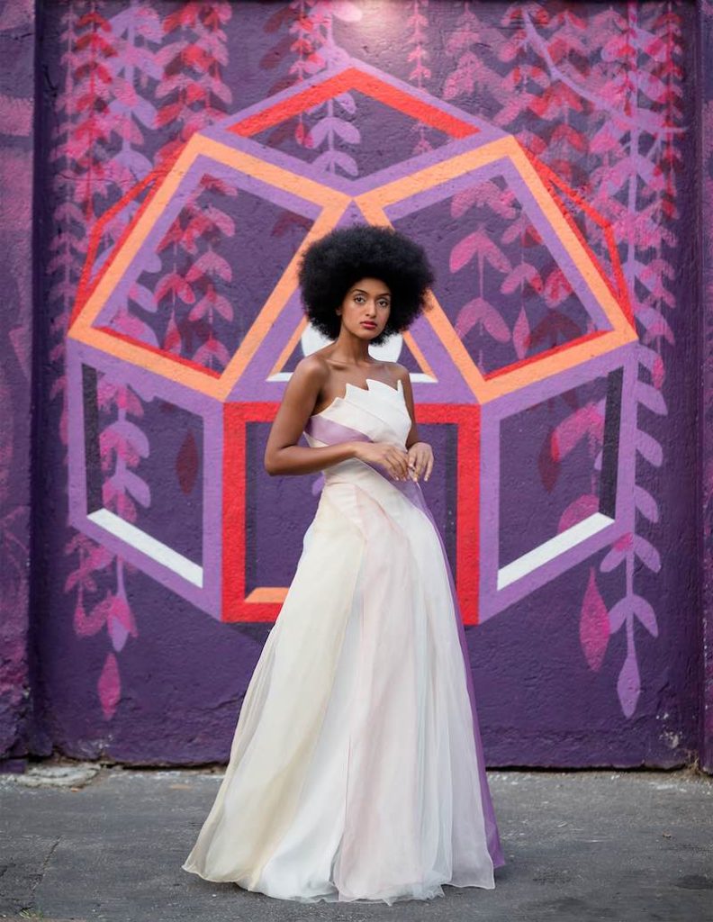In questa foto una modella posa indossando un abito da sposa scivolato con dettaglio di colore viola sul corpetto di Samthakhan, tra gli stilisti dell'atelier Le Fate Milano