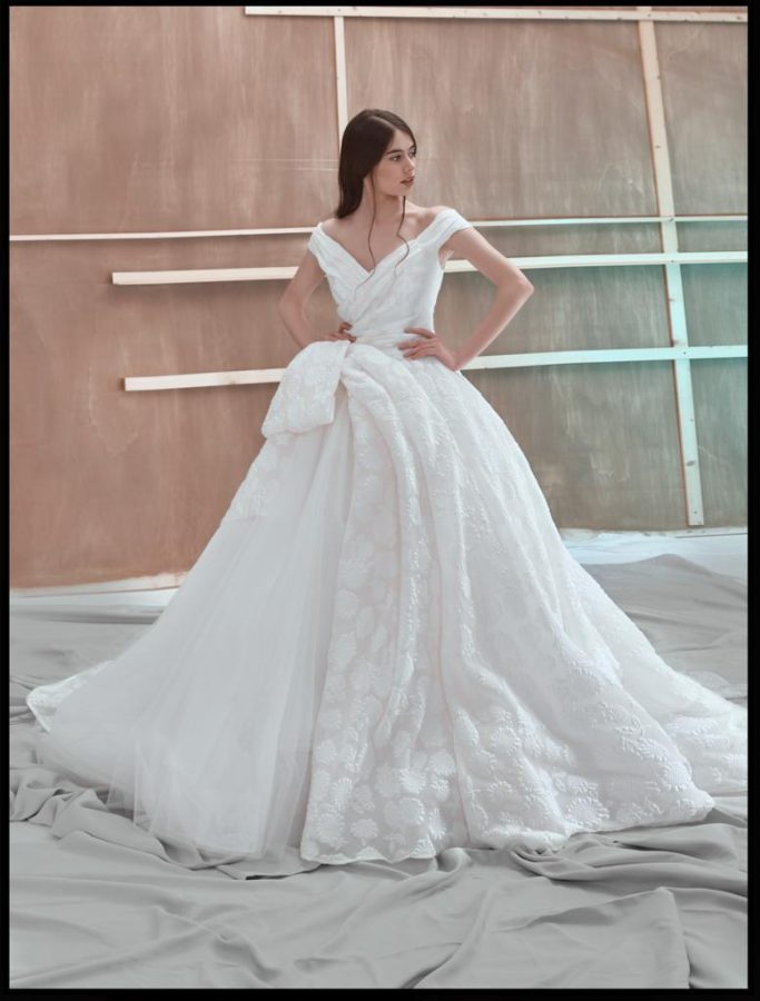 In questa foto una modella posa indossando un abito da sposa di Rosanna Perrone, ampio con maxi fiocco laterale