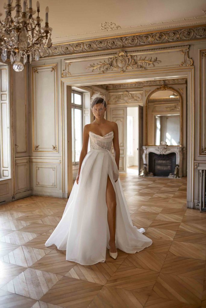 In questa immagine un modello con spacco di abiti da sposa Alon Livné White 2024.