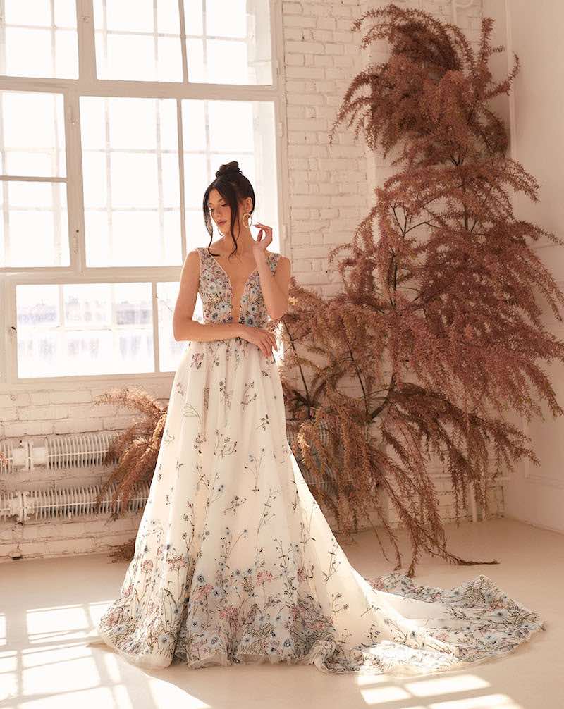 In questa foto una modella indossa un abito da sposa ad A Agnieszka Swiatly 2024 con scollo a V e stampa di piccoli fiori colorati all over