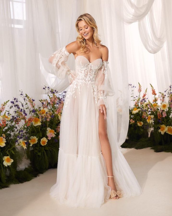 In questa foto una modella indossa un abito da sposa scivolato Agnieszka Swiatly 2024 con maniche a sbuffo staccabili, corpetto bustiere e microfiori ricamati