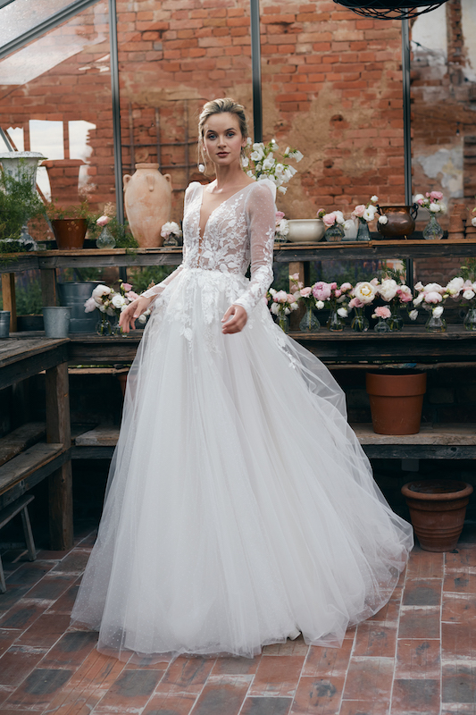In questa foto una modella indossa un romantico abito da sposa 2024, con gonna vaporosa in tulle, di Annais Bridal