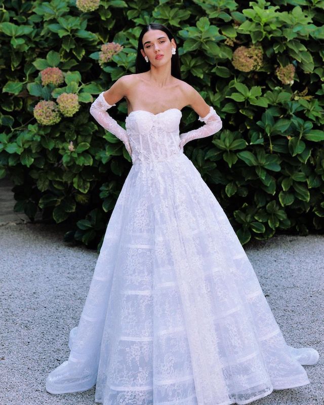 In questa foto una modella posa con un abito da sposa Bencivenga Alta Sartoria 2024