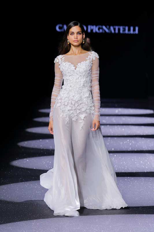 In questa foto una modella sfila in passerella con un abito da sposa Carlo Pignatelli 2024
