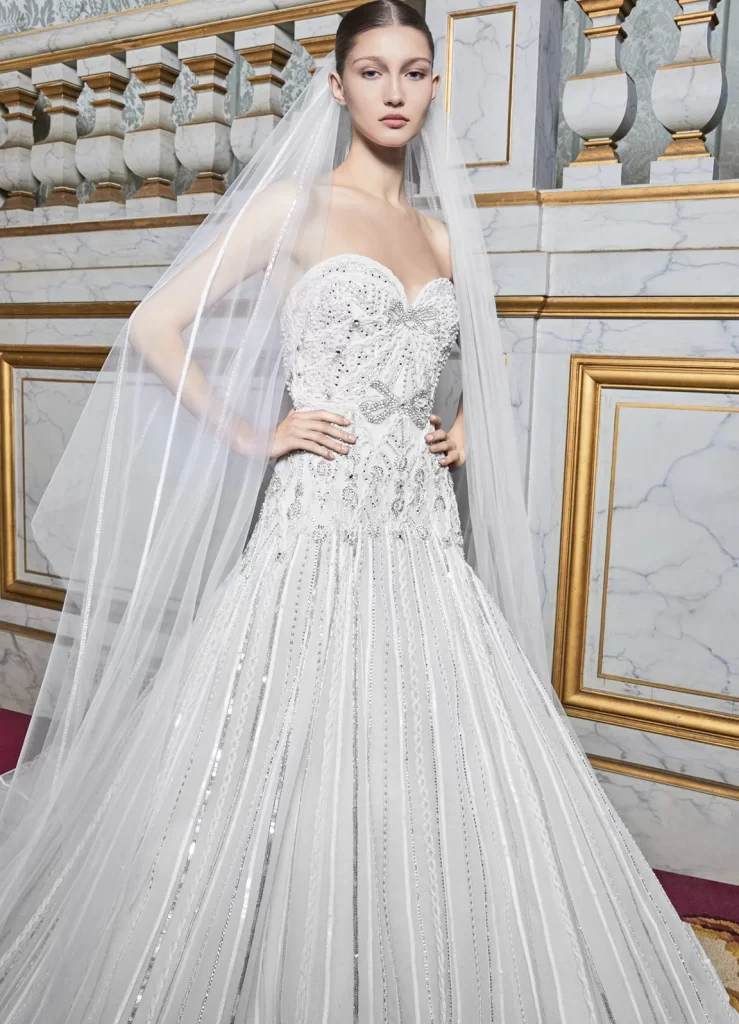 In questa foto una modella posa con un prezioso abito da sposa Elie Saab 2024: il modello è tra i 100 più belli della prossima stagione Bridal