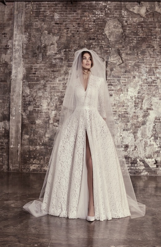 In questa foto un abito da sposa interamente in pizzo, con scollatura a V sul décolleté e spacco centrale, di Elisabetta Polginano. Il vestito fa parte dei 100 abiti da sposa 2024 più belli 