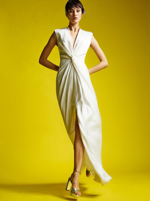 In questa foto una modella posa indossando un abito minimal, con nodo centrale sul busto, della linea Max Mara Bridal 2024