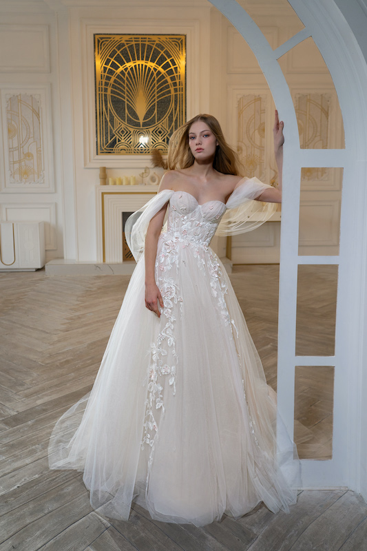 In questa foto una modella indossa un abito da sposa romantico della collezione bridal Papilio 2024