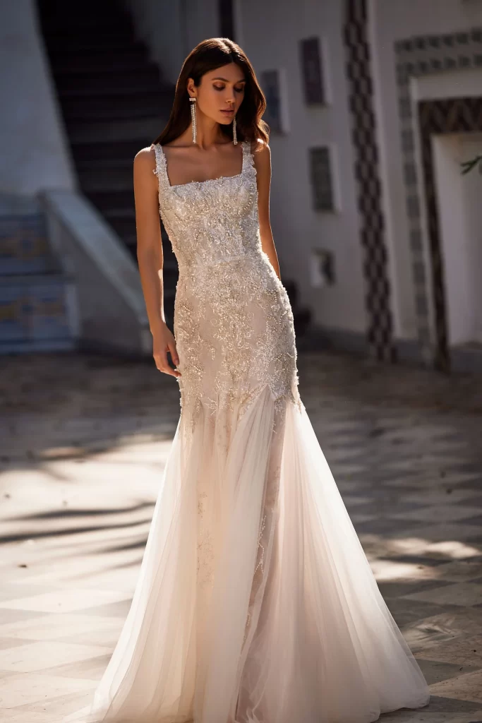 In questa foto una modella cammina indossando una semisirena con scollo quadrato di Pollardi: il vestito è tra i 100 abiti da sposa più belli per il 2024
