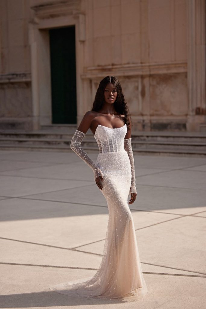 In questa foto una modella indossa un abito da sposa a sirena di Julie Vino con maniche a guanto staccabili