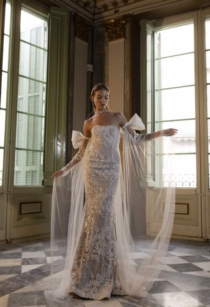 In questa foto una modella indossa uno dei modelli di abiti da sposa a sirena 2024 di Lorena Panea in pizzo e tulle e maniche con fiocco rimovibili
