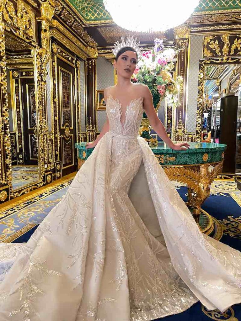 In questa foto una modella indossa uno dei modelli di abiti da sposa a sirena 2024 Nina Sarkisyants con sopragonna staccabile
