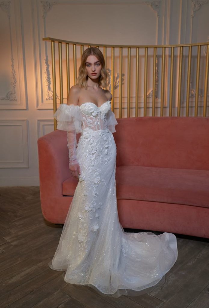 In questa foto una modella indossa uno dei modelli di abiti da sposa a sirena 2024 di Papilio con microfiori 3D all-over, scollo a cuore e corpetto bustier