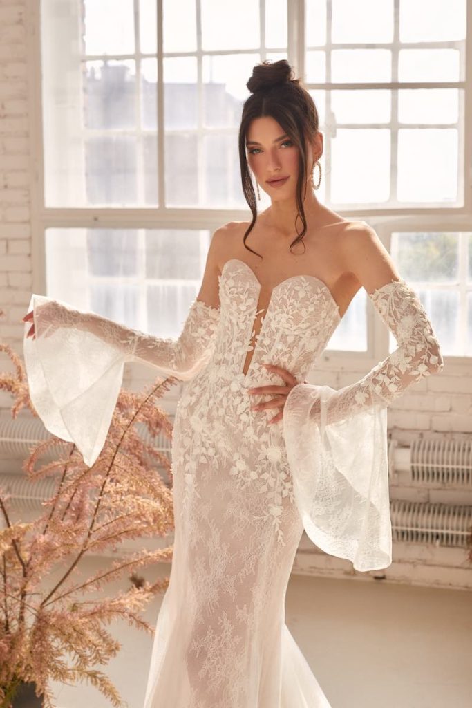 In questa foto una modella indossa un abito da sposa a sirena 2024 di Agnieska Swiatly con maniche a tulipano staccabili