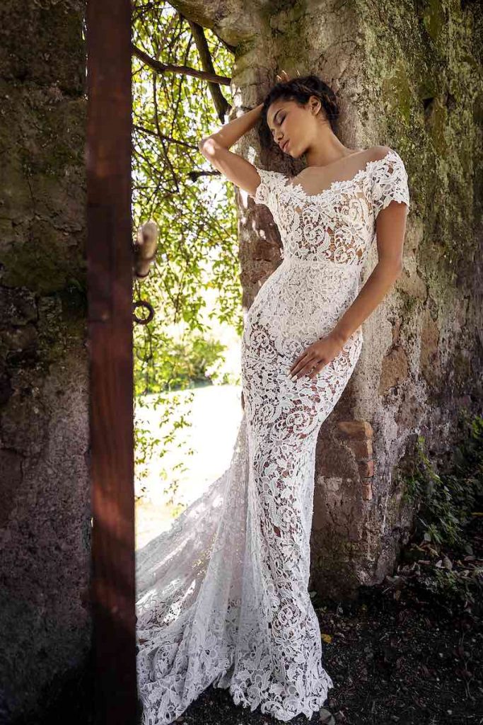 In questa foto una modella indossa un  abito da sposa a sirena di Andrea Sedici 2024 interamente in pizzo a tombolo con manichette