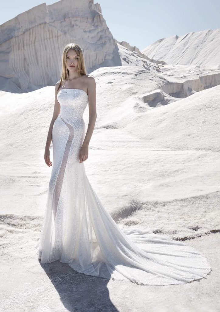 In questa foto una modella indossa un abito da sposa a sirena Atelier Pronovias con cut out che dal busto scende lungo la gonna