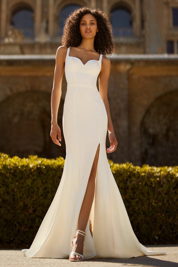 In questa foto una modella indossa uno dei modelli di abiti da sposa a sirena 2024 di Ines Di Santo con scollo a cuore e spacco frontale